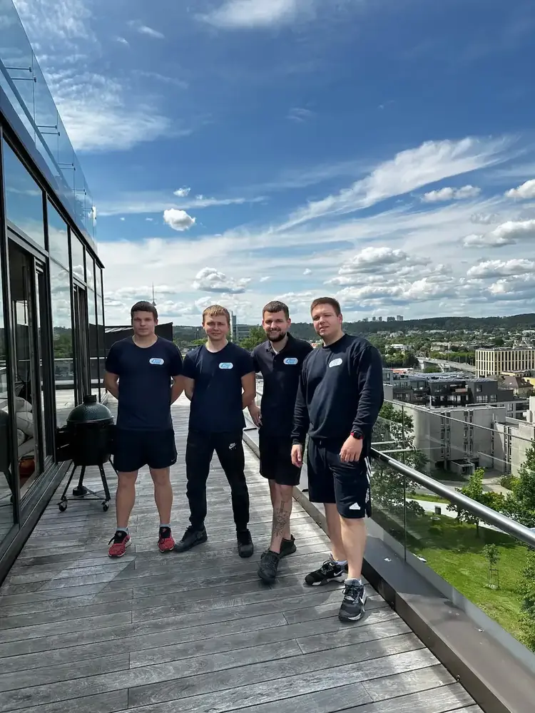 Moving crew of four in navy uniforms on a rooftop terrace